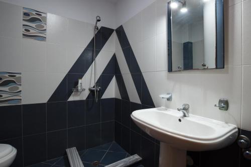 y baño con lavabo y espejo. en Hotel Fiorela 2009 en Gjirokastër