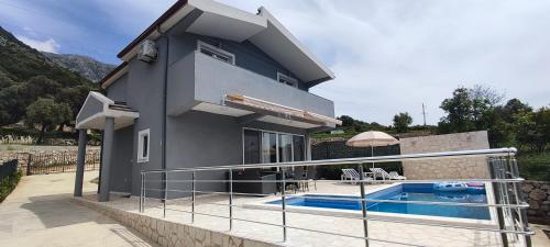 a house with a swimming pool in front of it at Zelena Maslina in Bar