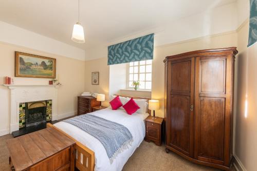 ein Schlafzimmer mit einem Bett und einem Kamin in der Unterkunft Lightfoot Cottage in Bishop Auckland
