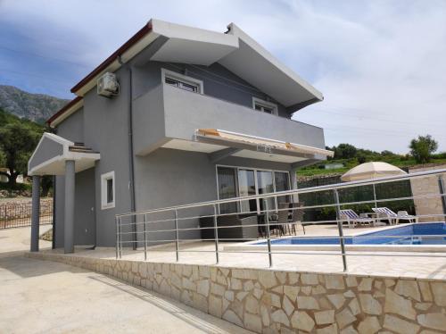 a house with a swimming pool in front of it at Zelena Maslina in Bar