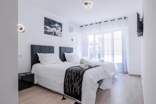 une chambre blanche avec un grand lit et une fenêtre dans l'établissement 2 bedrooms with terrace 100 metres from the sea, à Cannes