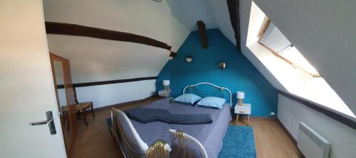 ein kleines Schlafzimmer mit einem Bett in einem blauen Zimmer in der Unterkunft Gite les Bruyères in Salbris