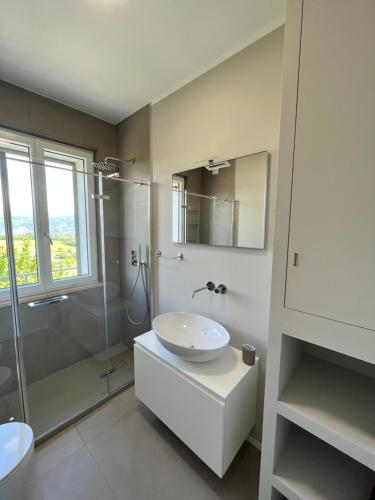 a white bathroom with a sink and a shower at Casa di campagna Colle Pertecone Locazione Turistica in Spoleto