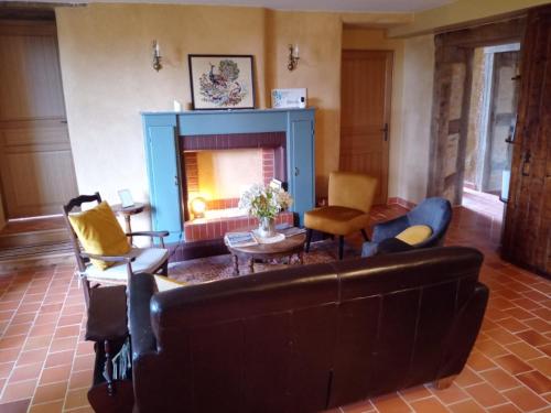 a living room with a couch and a fireplace at à la Mainguère, chambres d'hôtes in Brécé