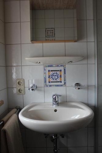 a bathroom with a white sink and a mirror at Apartment Andrea - Chiemgau Karte in Inzell