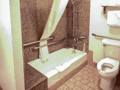 a bathroom with a bath tub and a toilet at Motel 6 Portland OR Southeast in Portland