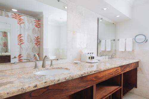 a bathroom with two sinks and a large mirror at The Buccaneer Beach & Golf Resort in Christiansted