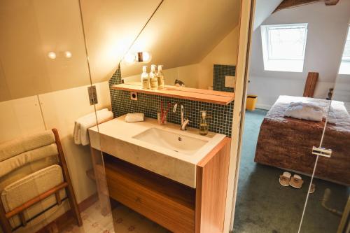 baño con lavabo y 1 cama en una habitación en Hôtel Château - Domaine de Coeurmandie en Bény-sur-Mer