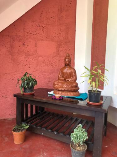 a statue sitting on a table with plants on it at Kamoga Homestay in Virajpet