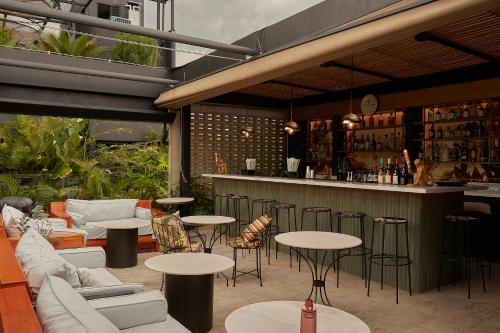 a patio with tables and chairs and a bar at Celestino Boutique Hotel & Spa in Medellín