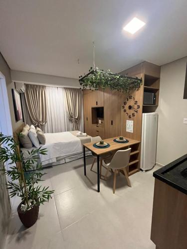 Cet appartement comprend une chambre avec un lit et une table ainsi qu'une cuisine. dans l'établissement Studios London, à Resende