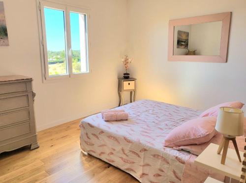 1 dormitorio con cama, tocador y espejo en La ROSÉE des Cévennes Gîte 120m2 à 5min d'Anduze en Massillargues-Attuech