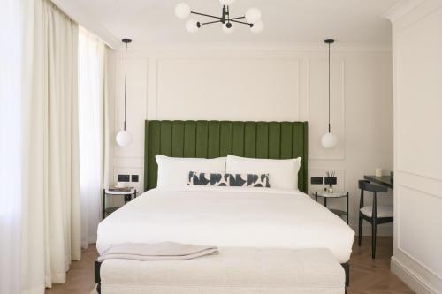 a bedroom with a large white bed with a green headboard at The Store in Oxford