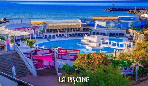 un complexe avec une piscine à côté de l'océan dans l'établissement CapNat 340 Pas Seulement Desire, au Cap d'Agde