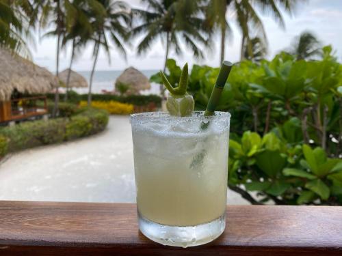 a drink sitting on a table next to a resort at St. George's Caye Resort in Belize City