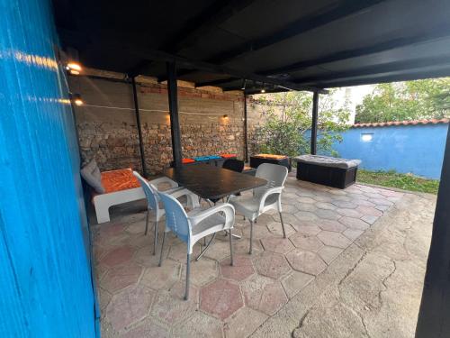 a patio with a table and chairs and a couch at Blue Orange Lake Hostel in Ohrid