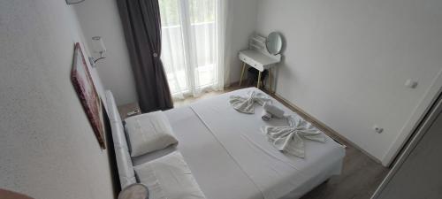 a mirror reflecting a bedroom with a bed and a window at Zelena Maslina in Bar