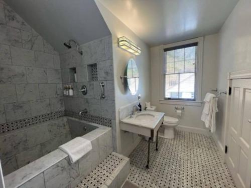 ein Badezimmer mit einer Badewanne, einem Waschbecken und einer Badewanne in der Unterkunft Historic Coast Guard House and Cottages in Point Arena