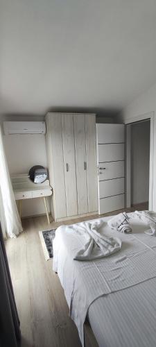 a bedroom with a white bed and a desk at Zelena Maslina in Bar