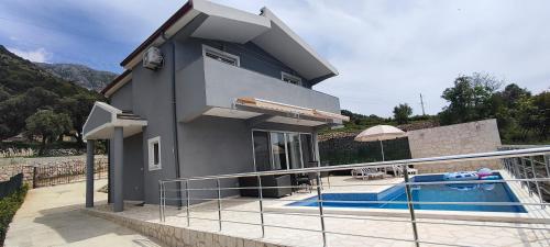 a house with a swimming pool in front of it at Zelena Maslina in Bar