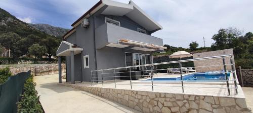 a house with a swimming pool in front of it at Zelena Maslina in Bar