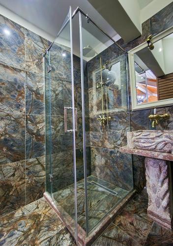 a shower with a glass door in a bathroom at Villa Parku Rinia in Korçë