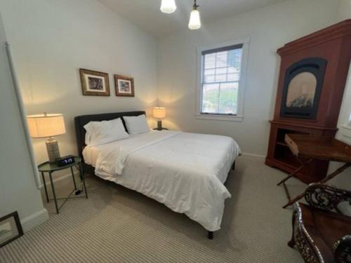 Un dormitorio con una gran cama blanca y una ventana en Historic Coast Guard House and Cottages, en Point Arena