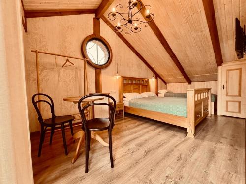 1 dormitorio con 1 cama, mesa y sillas en VinoOdor - ვინოოდორ, en Telavi