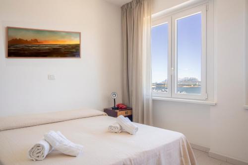 a hotel room with two beds and a window at Hotel De Plam in Olbia