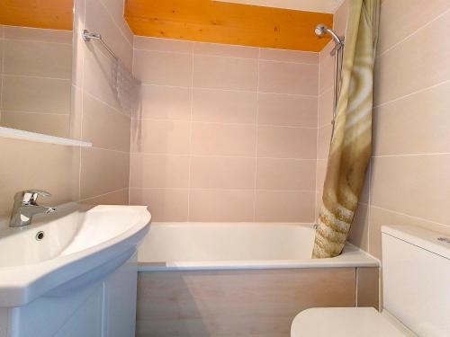 une salle de bain avec un lavabo, une baignoire et des toilettes dans l'établissement Studio cosy au pied des pistes avec balcon, 3 couchages et cuisine équipée - FR-1-344-1056, aux Menuires