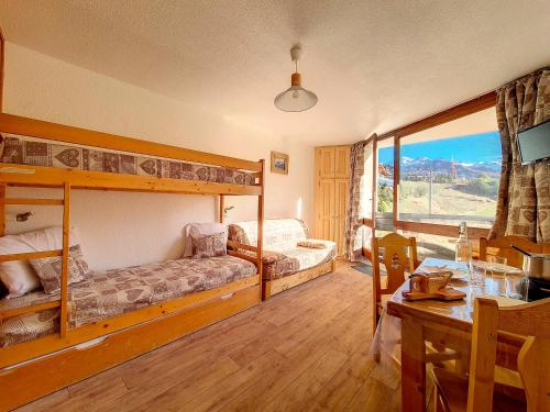 - une chambre avec 2 lits superposés et une salle à manger avec une table dans l'établissement Studio cosy au pied des pistes avec balcon, 3 couchages et cuisine équipée - FR-1-344-1056, aux Menuires