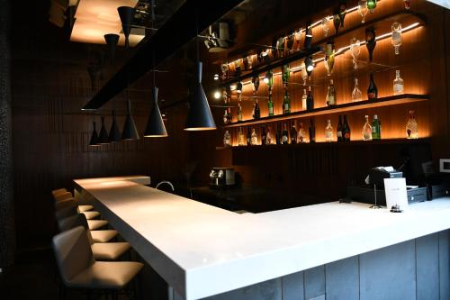 a bar with a white counter and some bottles at Faqra Hills Hotel in Kfardebian