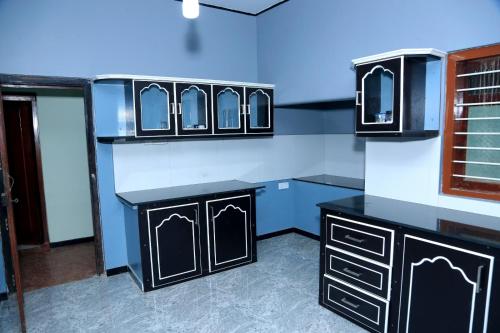 a bathroom with black cabinets and mirrors on the wall at Urumpirai Holidays in Jaffna