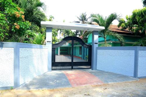 a black gate in front of a fence at Urumpirai Holidays in Jaffna