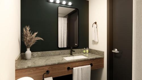uma casa de banho com um lavatório e um espelho em Northwinds Hotel Revelstoke em Revelstoke