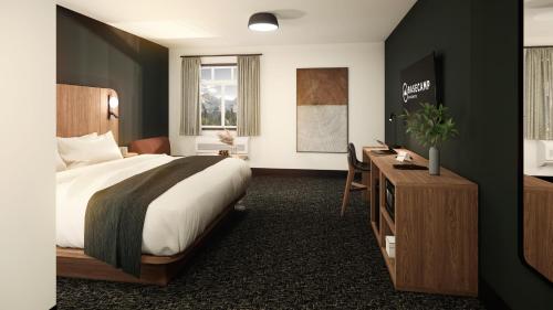 um quarto de hotel com uma cama e uma secretária em Northwinds Hotel Revelstoke em Revelstoke