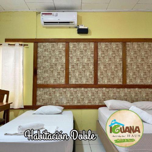 two beds in a hotel room with avertisement at IGUANA HAUS IQUITOS in Iquitos