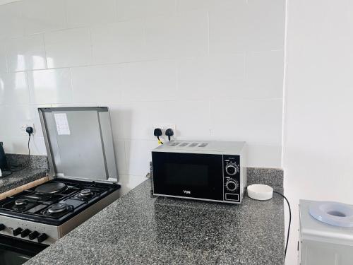 a microwave sitting on a counter next to a stove at Bharazah Luxury Apartment in Malindi