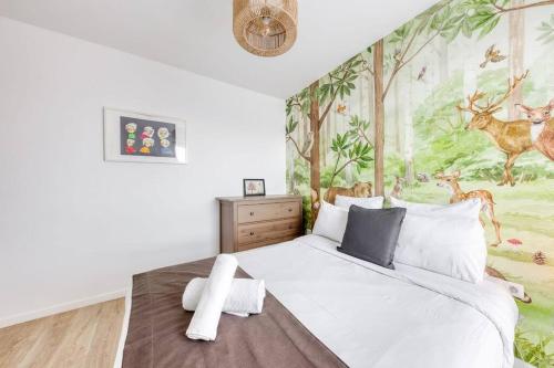 um quarto com uma grande cama branca e um mural em Appartement Neuf avec Terrasse em Bobigny