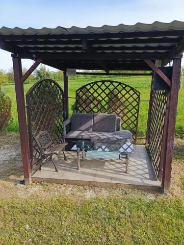 a gazebo with a bed and a bench in a field at W Rajbrocie u Ewusi in Rajbrot