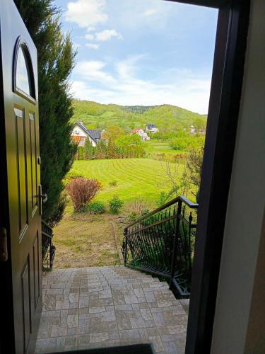 an open door with a view of a golf course at W Rajbrocie u Ewusi in Rajbrot