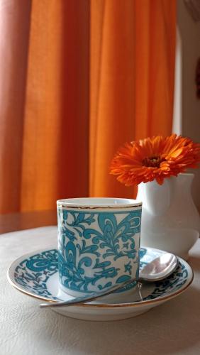 a blue and white cup on a plate with a flower at Arca Hotel in Pienza