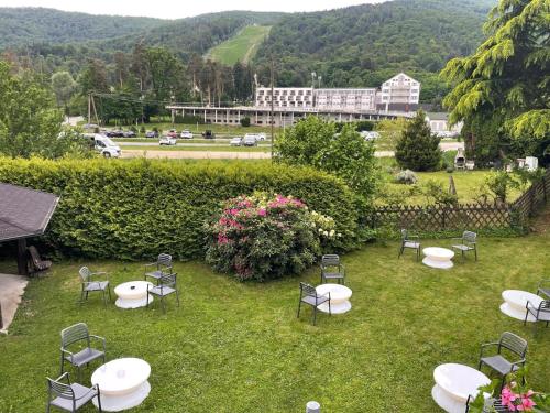 a group of tables and chairs in the grass at Boutique Hotel Pohorje in Maribor