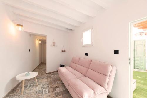 ein Wohnzimmer mit einem rosa Sofa und einem Tisch in der Unterkunft El Patio de Rafaela in El Cerro