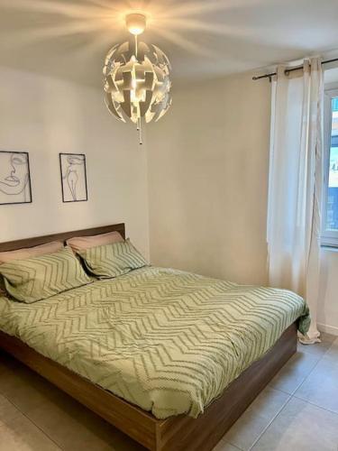 une chambre avec un lit et un lustre dans l'établissement Charmant 2P cœur de ville et plage, à Sainte-Maxime