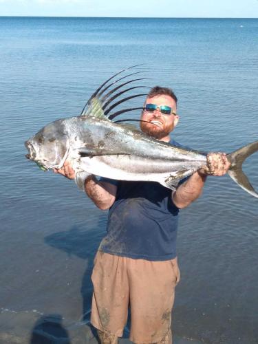 a man holding a large fish in the water at Villa Las Mellizas in Puerto Armuelles