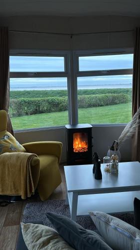 a living room with a fireplace in front of a window at Traumblick Nr 3 aufs Wattenmeer Blick bis nach Texel in Westerland