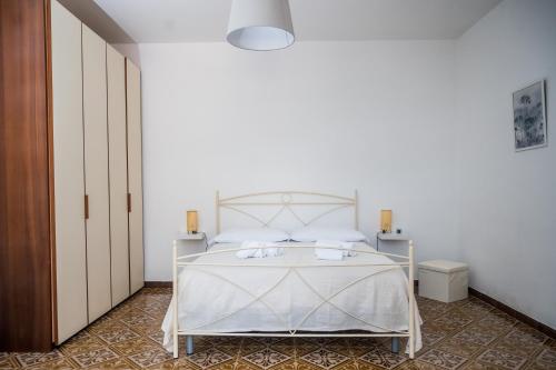 Dormitorio blanco con cama blanca y almohadas blancas en Terrazza Mediterranea en Vietri