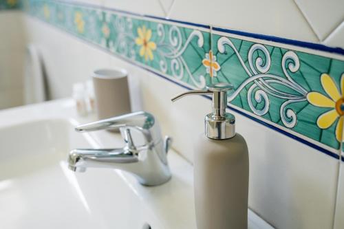 a bathroom sink with a soap dispenser on it at Terrazza Mediterranea in Vietri sul Mare
