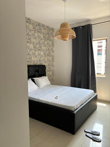 Un dormitorio con una cama con marco de cama negro. en HAYDEN HOME, en Libreville